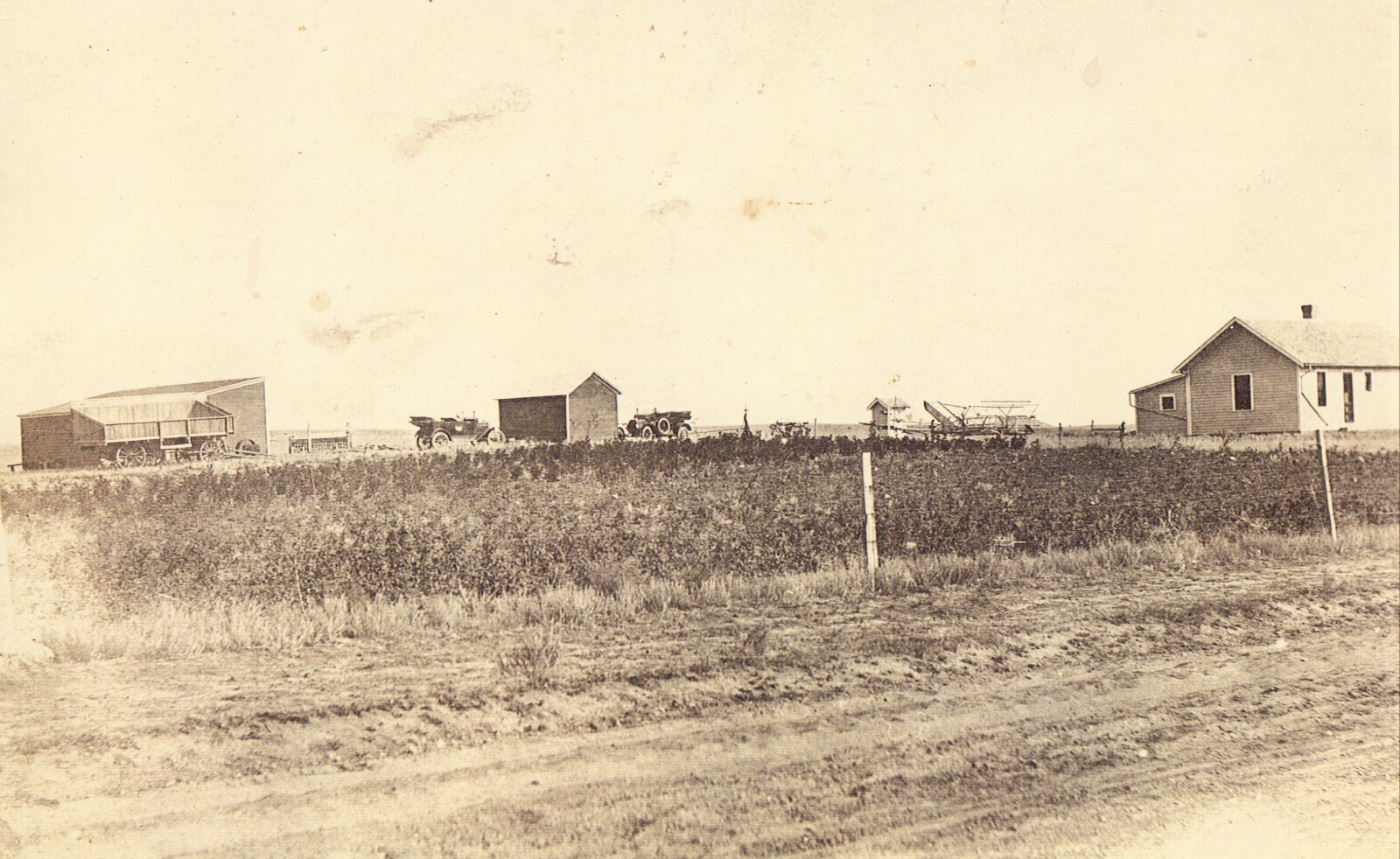 Real Photo Postcard-Farm Unknown location. Old cars