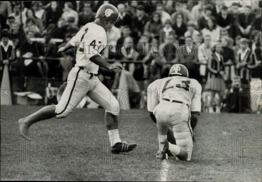 1965 Press Photo Football players on the field watched by spectators during game