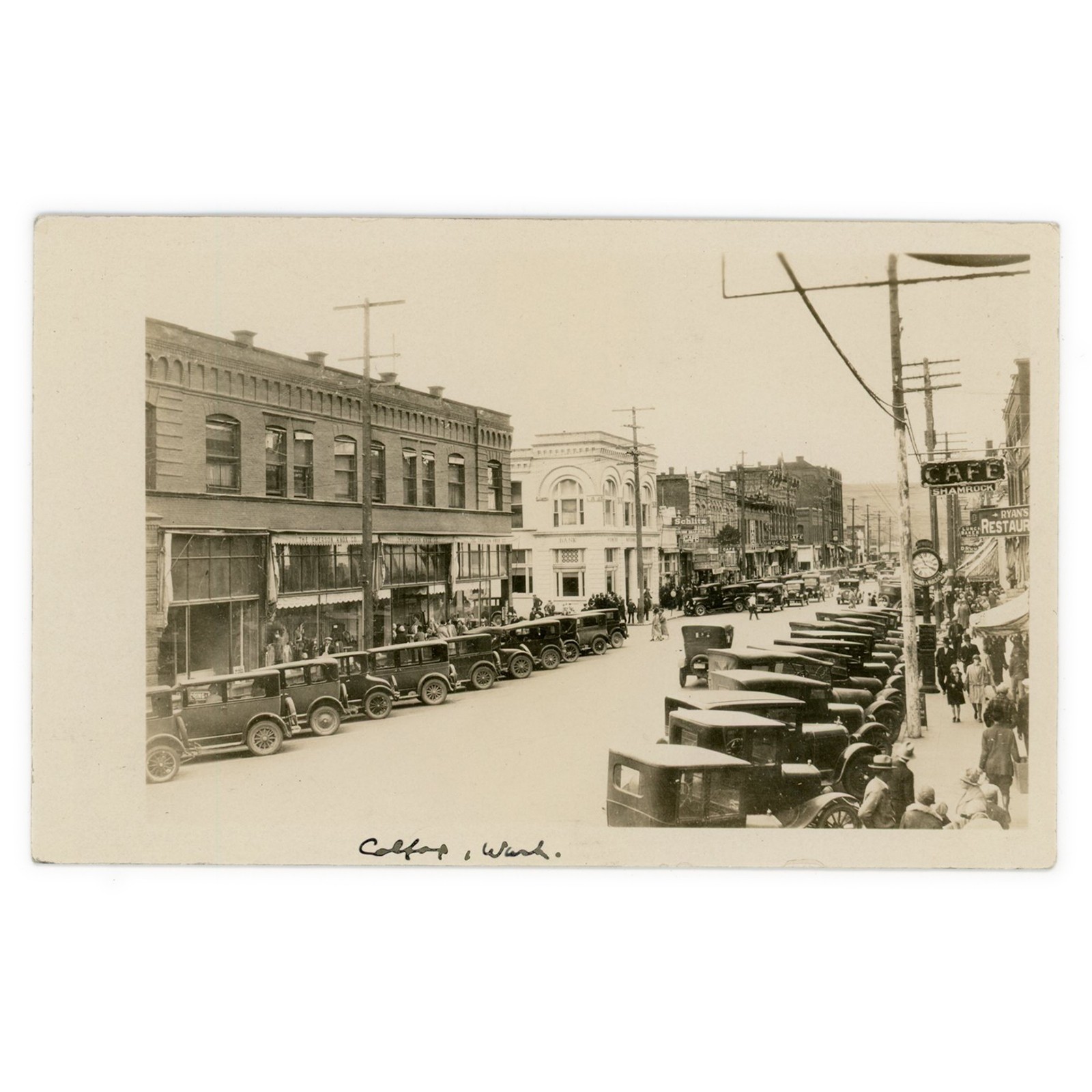 Photo Postcard of Colfax Washington Main Street - 1920s RPPC Cars Shops Clock