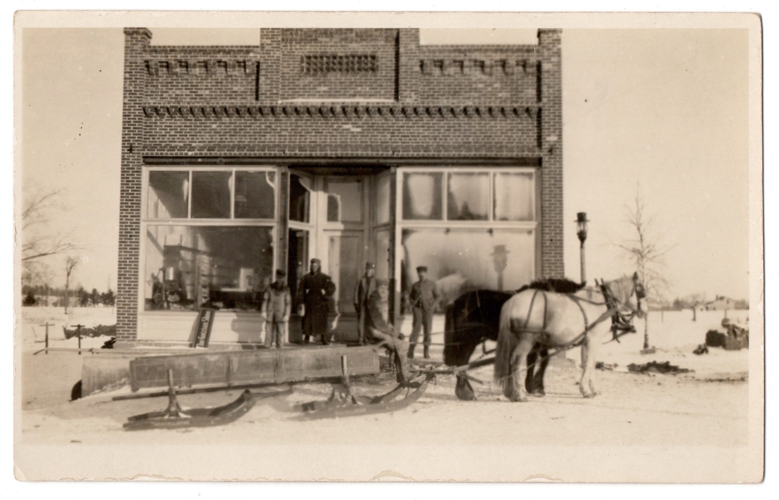 Vintage RPPC Winter Scene Horse Drawn Sleigh Men Brick Storefront Postcard