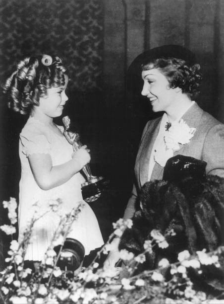 The American Actress Claudette Colbert congratulating Shirley Temp- 1935 Photo