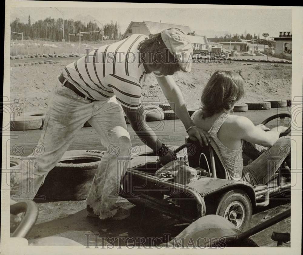 1975 Press Photo Man pushes a man in a go-kart - lrb33189