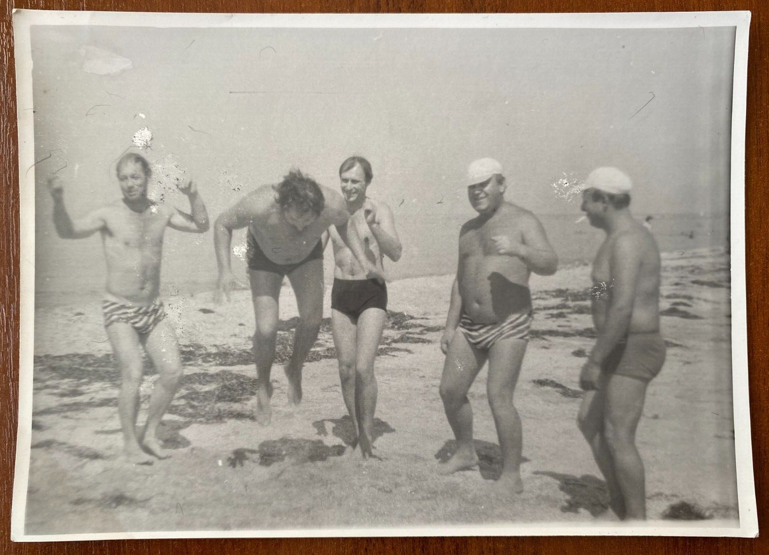 Affectionate gentle men in swim trunks dance on beach naked torso bulge gay int