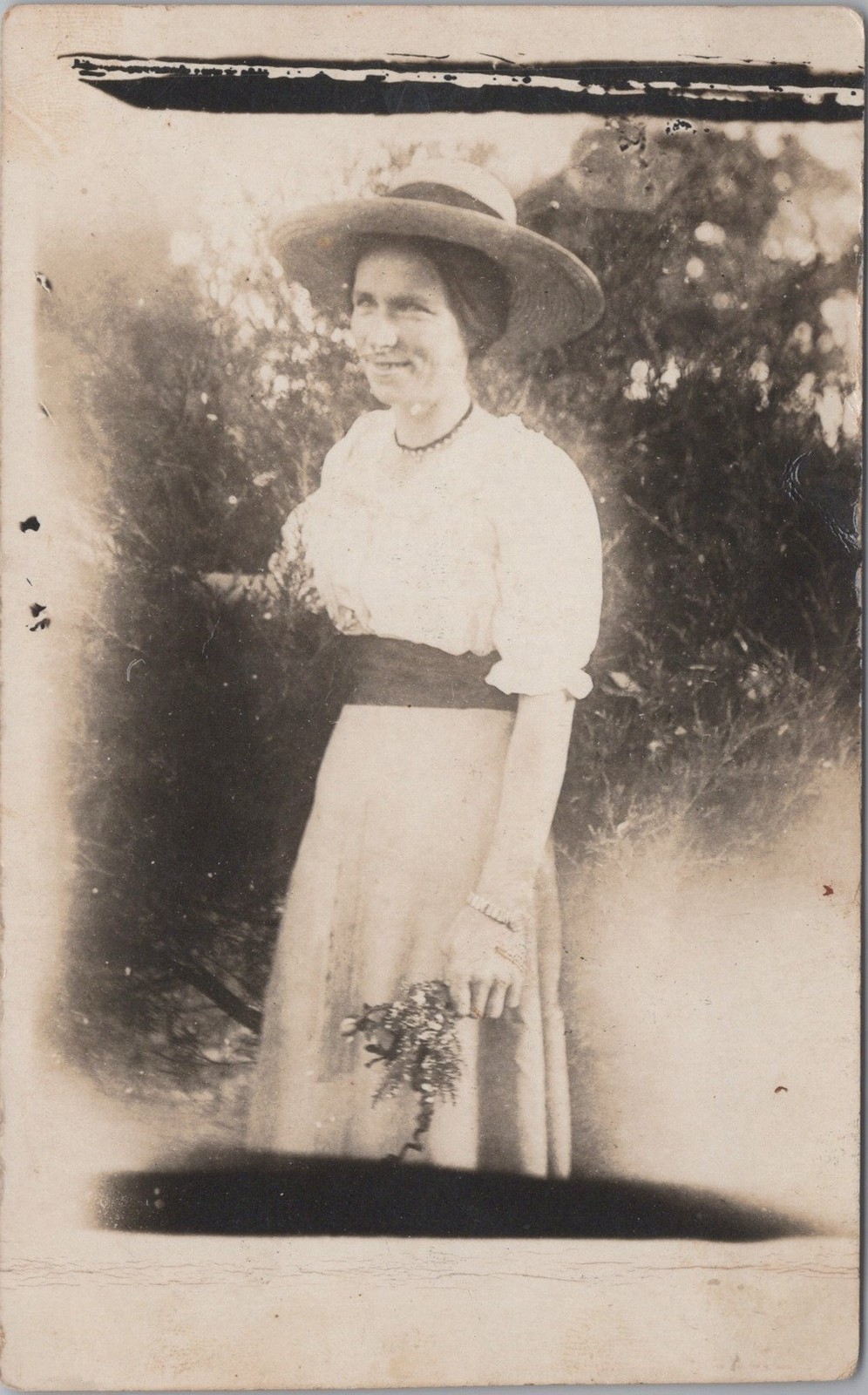 Woman in a hat and dress, posed outdoors RPPC Real Photo Postcard