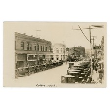 Photo Postcard of Colfax Washington Main Street - 1920s RPPC Cars Shops Clock picture
