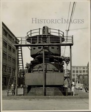 1949 Press Photo Woman stands and studies a huge General Electric turbine picture