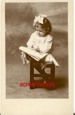 C1910 RPPC PHOTO YOUNG SPECTACLED GIRL CHILD READING MAGAZINE OR PAPER VG picture