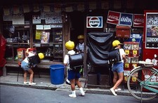 Three young Japanese schoolboys wearing yellow caps carrying large- Old Photo picture