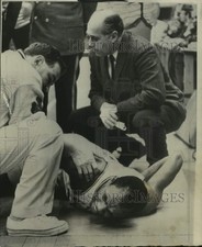 1965 Press Photo Injured Basketball Player Getting Medical Attention On Court picture